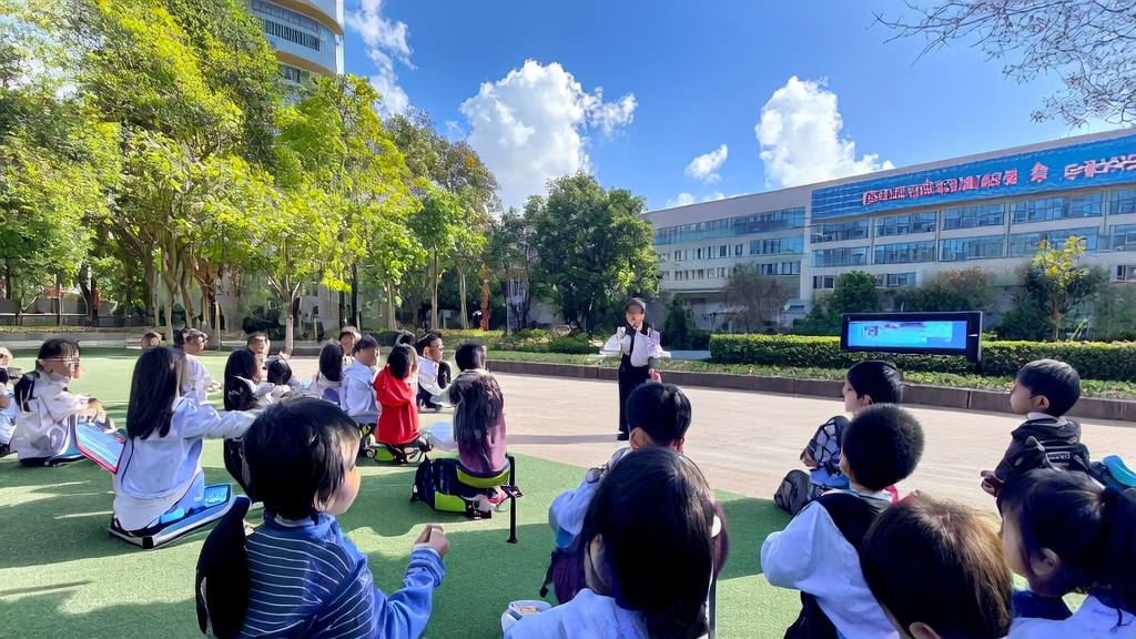 学生们在学校使用AI工具进行互动学习，背景是教学楼和阳光明媚的操场