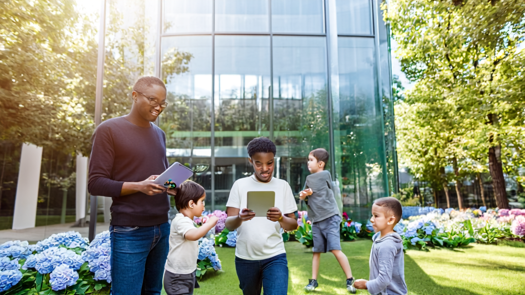 Silicon Valley parents showcase their AI language learning tool while children play joyfully in the sunshine